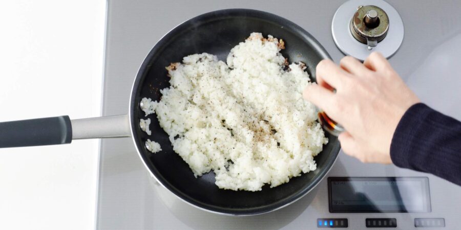 Adding soy sauce to the rim of the pan.