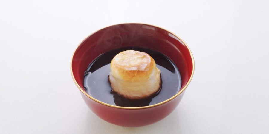 Bowl of oshiruko topped with a piece of toasted mochi.