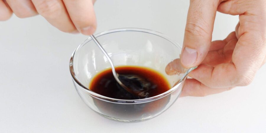 Mixing teriyaki sauce in a glass bowl.