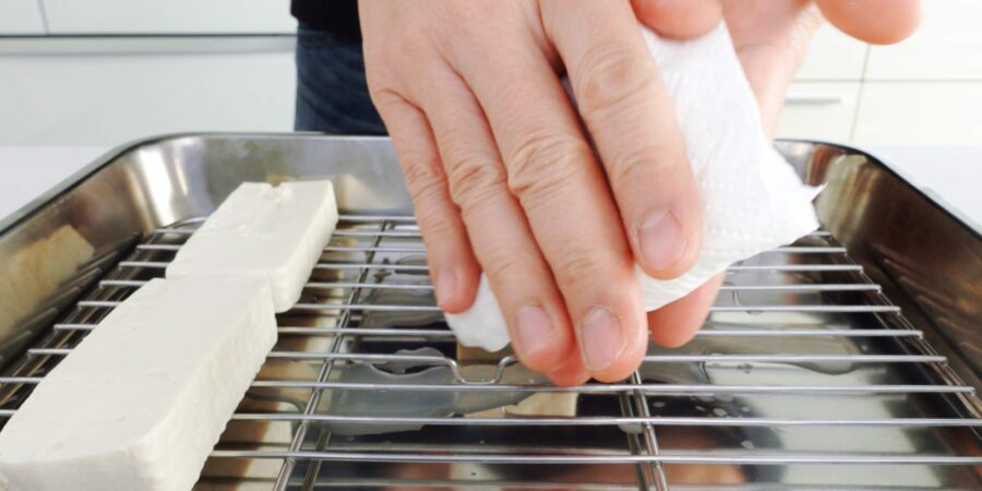 Drying off the surface of the tofu.