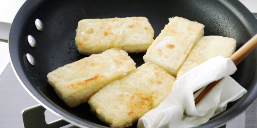 Crispy browned tofu in a frying pan.