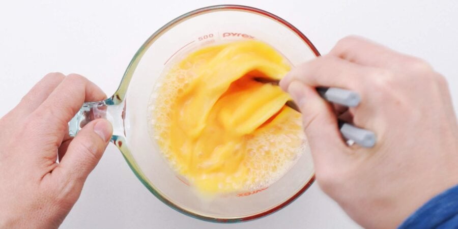 Whisking eggs into dashi.