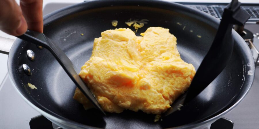 Shaping dashimaki tamago in a round pan.