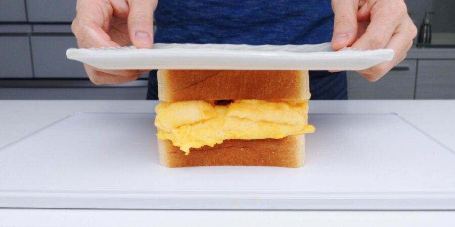 Pressing Tamagoyaki Sandwich with a plate.