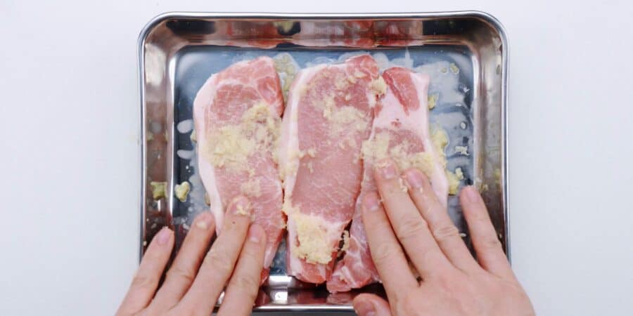 Marinating pork chops in ginger to make shogayaki.