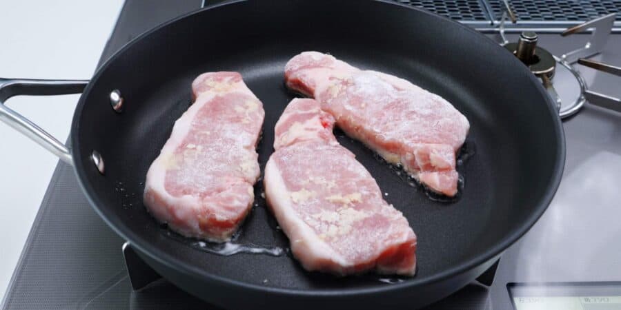Ginger pork chops in a frying pan.