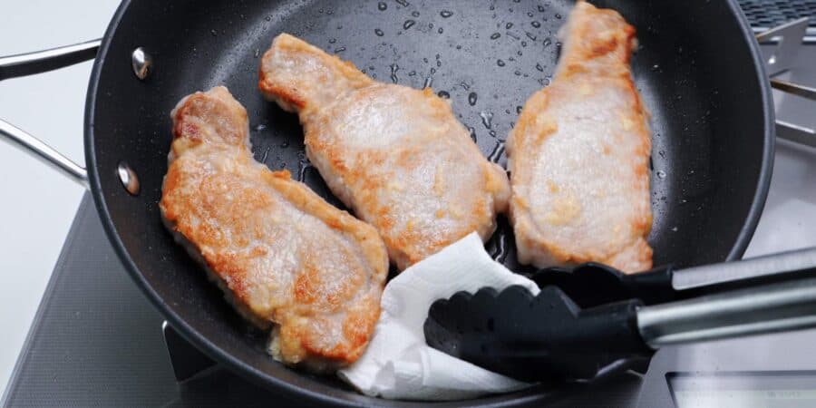 Soaking up excess oil in the pan after frying Japanese pork chops.