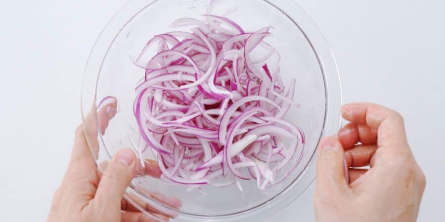 Tossing sliced red onions in a lime juice, salt, and sugar to quick pickle.