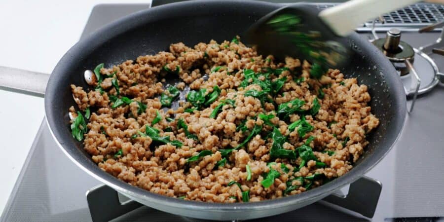 Basil chicken lettuce wrap filling in a frying pan.