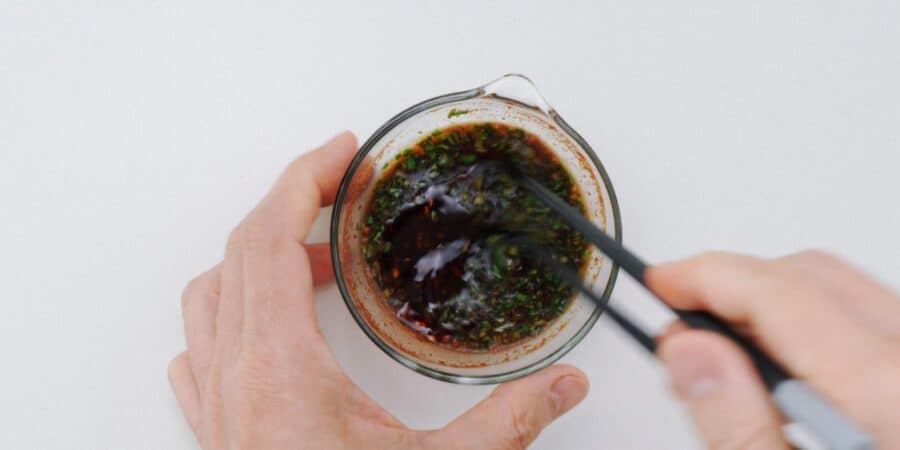 Whisking chili oil into a spicy potsticker dipping sauce for gyoza.