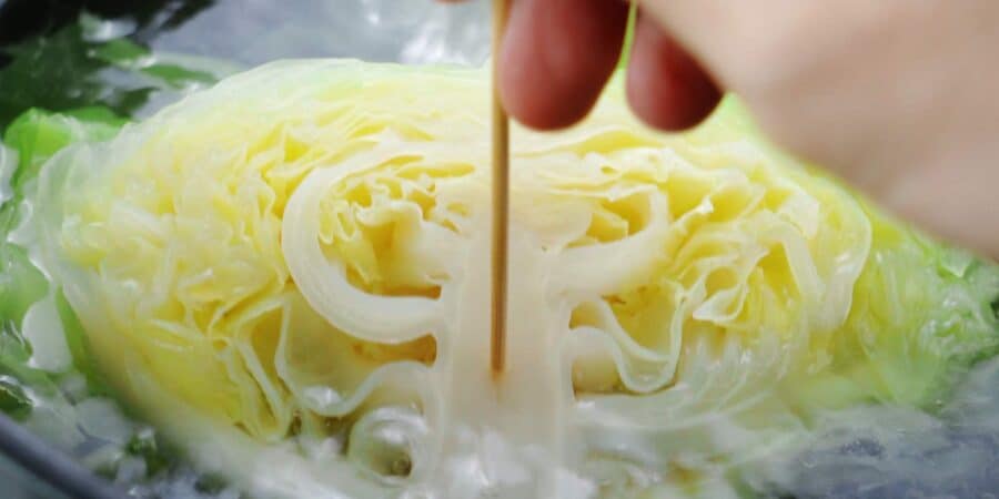 Testing a half head of cabbage with a skewer.