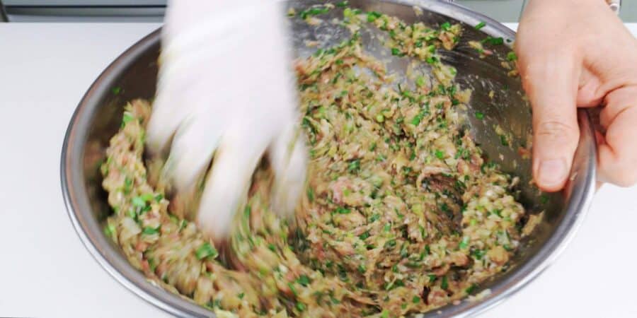Mixing gyoza filling ingredients together by hand.