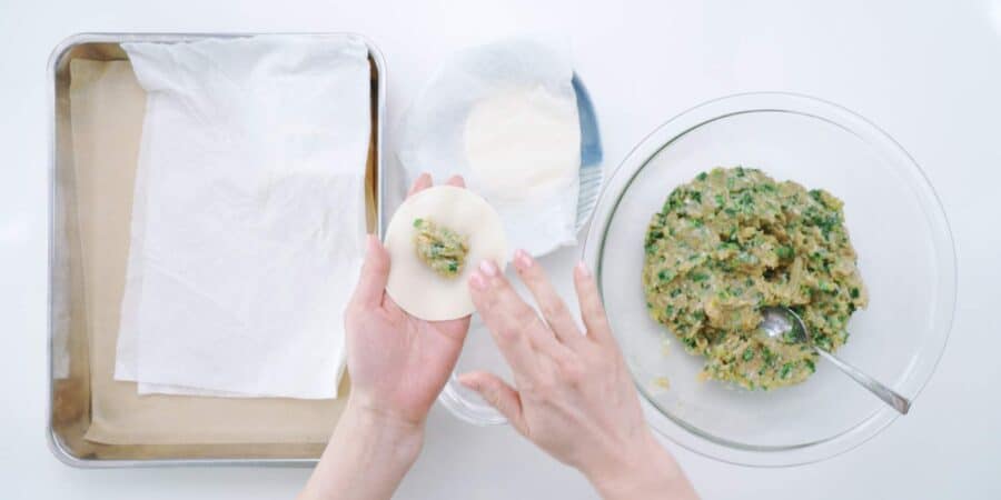 Wetting the rim of a gyoza wrapper for folding the dumplings.