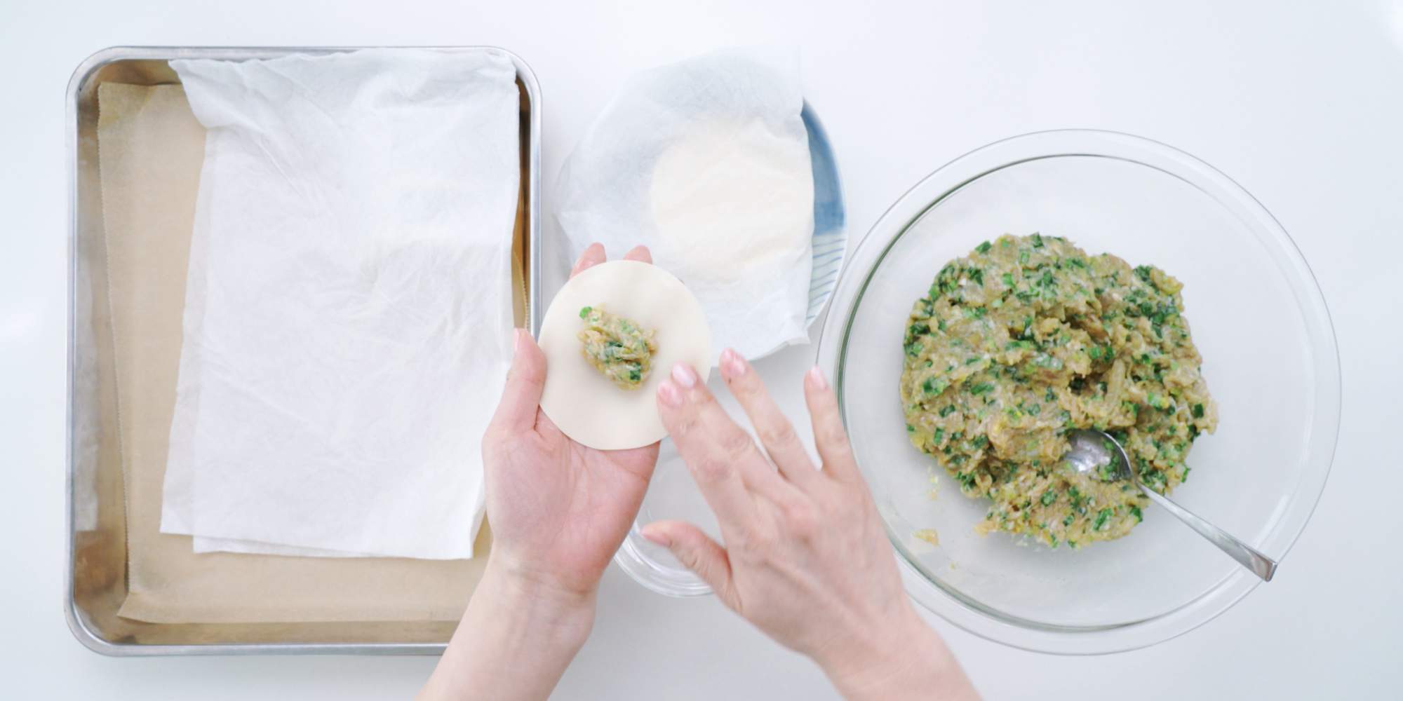Wetting the rim of a gyoza wrapper for folding the dumplings. - 4