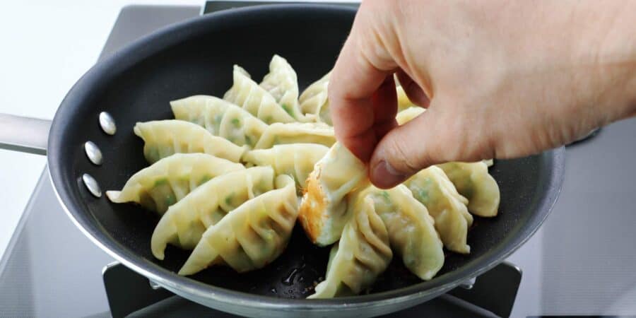 Pan-fried potstickers with a golden brown bottom.