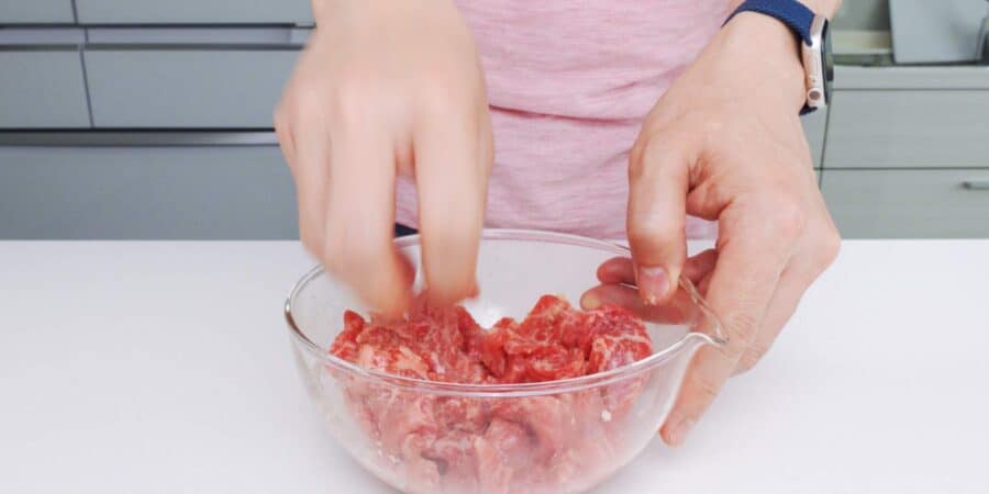 Marinating thinly sliced beef with ginger, garlic, soy sauce, and sake.