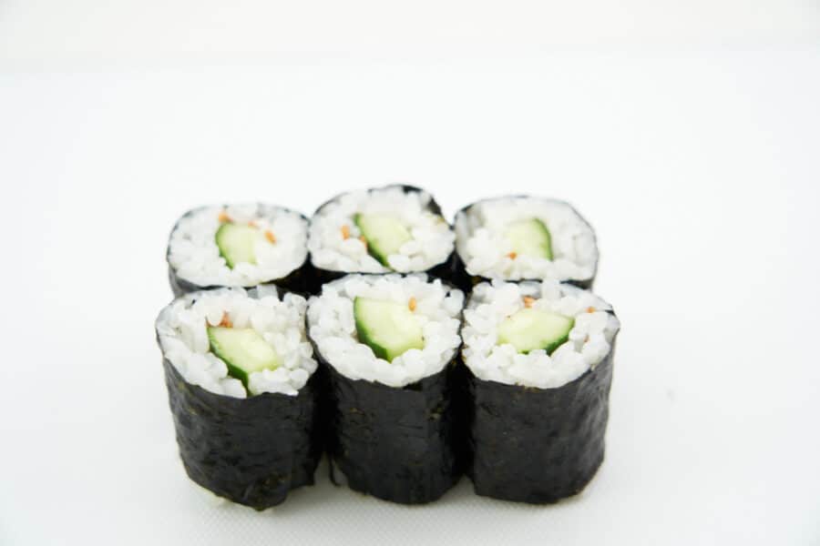 Close-up shot of the cucumber sushi roll, emphasizing the texture of the sushi rice and the crisp cucumber.