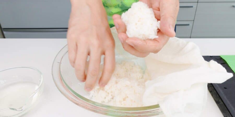 Scooping 80 grams of sushi rice for making a sushi roll.