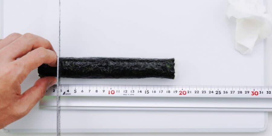 Using a ruler to cut sushi rolls.