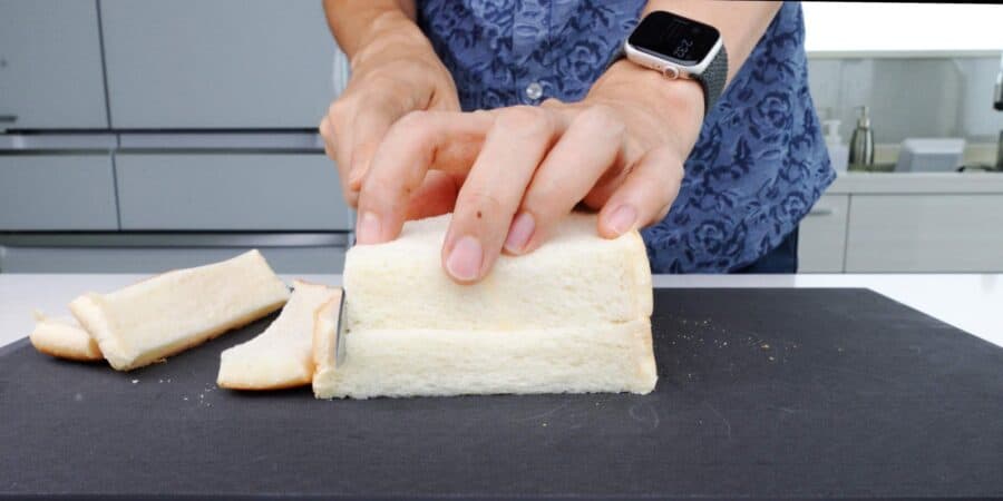 Slicing crusts off sandwich bread to make panko.
