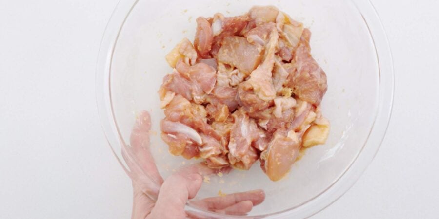 Mixing in potato starch into marinated chicken.