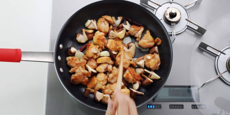 Stir-frying garlic, chicken, and mushrooms.