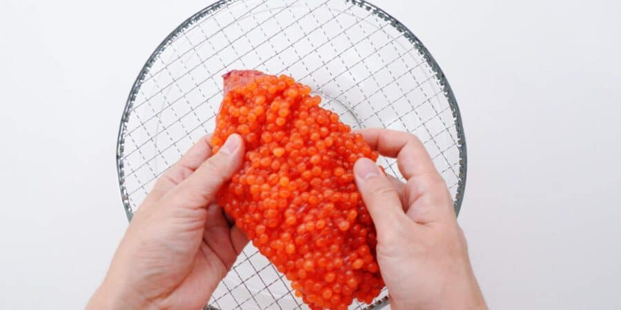 Splitting a skein of salmon roe.