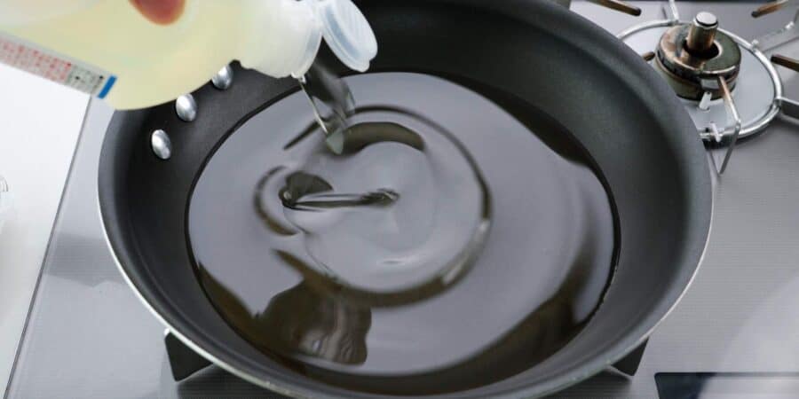 Adding oil to a frying pan.
