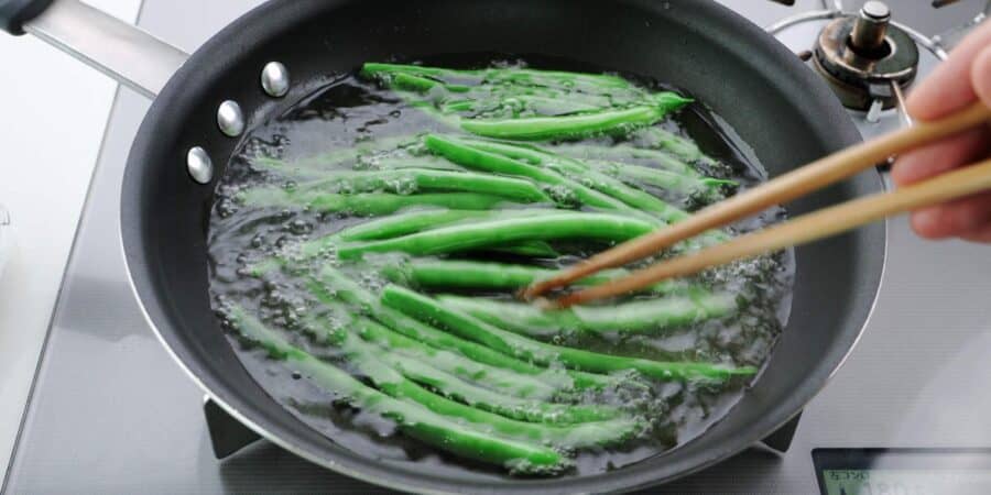 Oil blanching green beans.