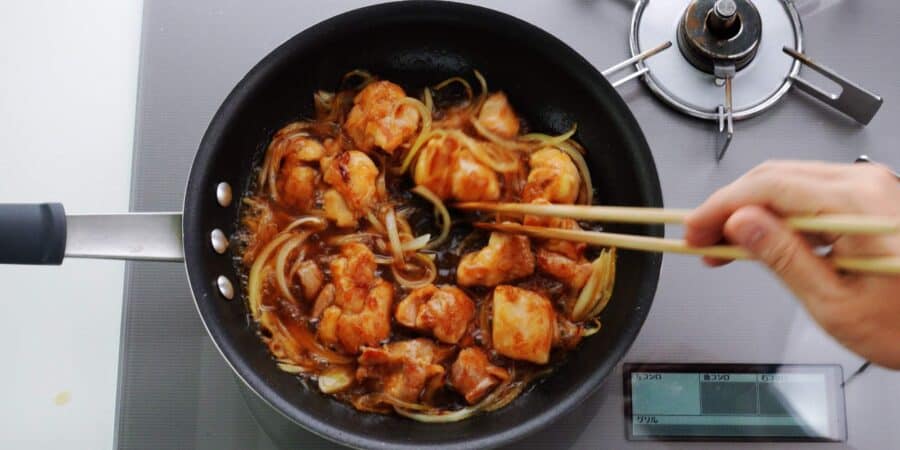 Chicken and onions cooking in dashi for oyakodon.