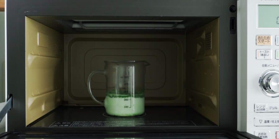 Heating milk, white chocolate, and matcha in the microwave oven.