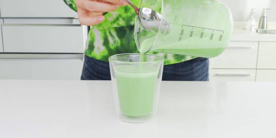 Serving matcha latte in an insulated glass mug.