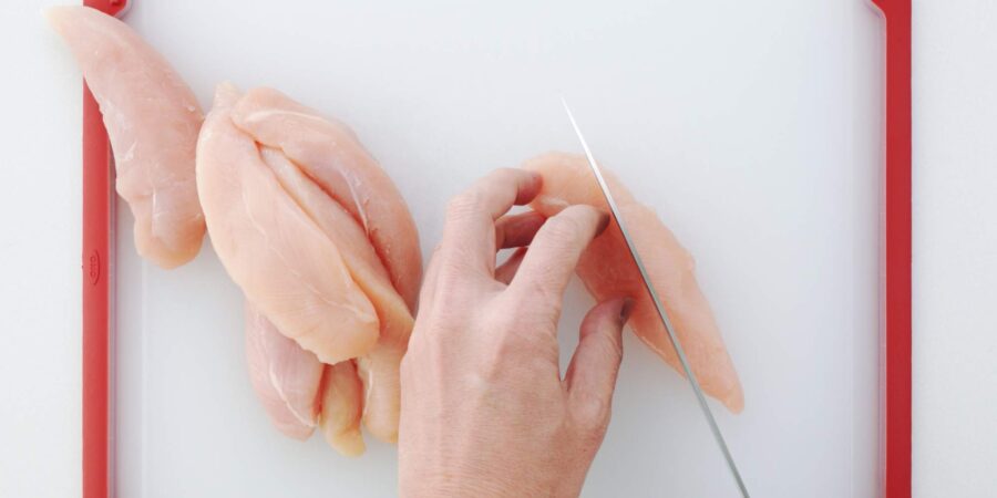 Slicing chicken into strips.