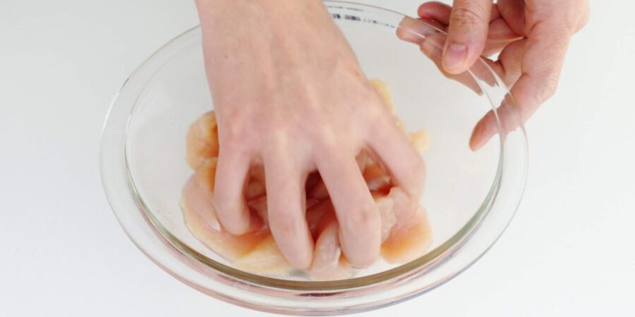 Marinating chicken strips with sake, salt, and ginger.