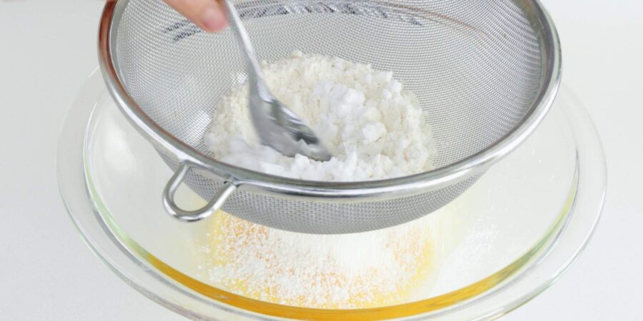 Sifting flour and potato starch into tempura batter.