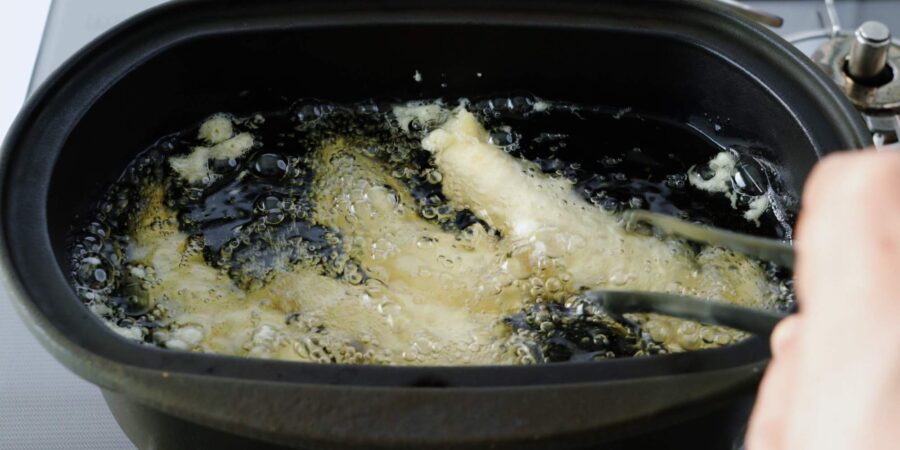 Deep frying chicken tempura strips