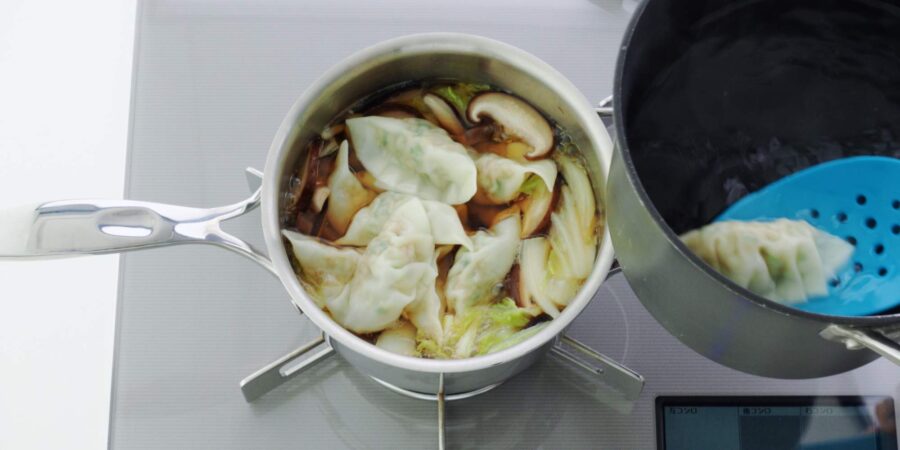 Transferring boiled gyoza to soup.
