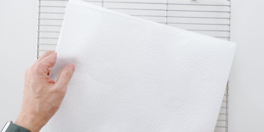Lining a wire rack with paper towels.
