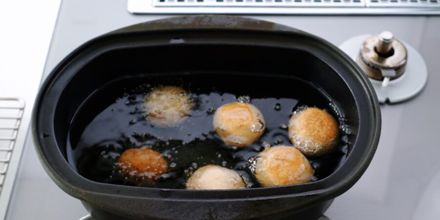 Deep frying Sata Andagi.