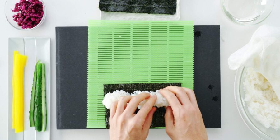 Spreading seasoned sushi rice on nori.