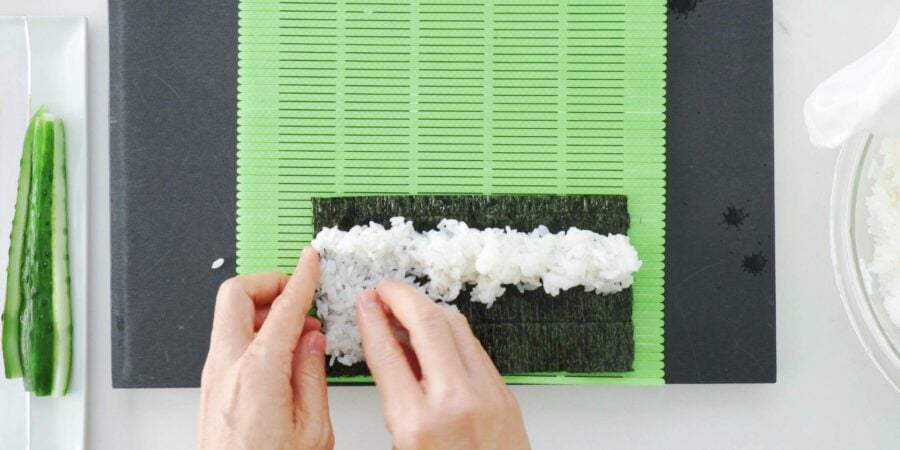 Spreading sushi rice on nori to make a hosomaki style roll.