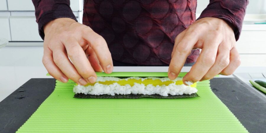 Rolling pickled vegetable sushi roll.