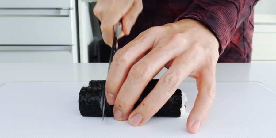 Cutting hosomaki sushi rolls.